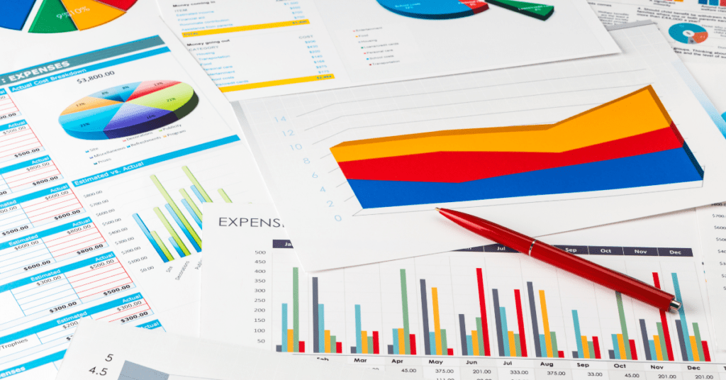 Spread of financial documents with colorful charts, graphs, and a red pen, emphasizing the analysis of expenses and financial data.